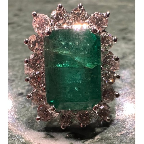 869 - A certified emerald and diamond cluster ring, central Zambian elongated octagonal step cut emerald, ... 