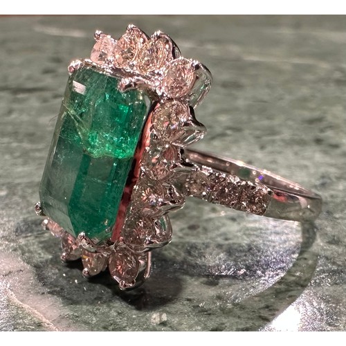 869 - A certified emerald and diamond cluster ring, central Zambian elongated octagonal step cut emerald, ... 