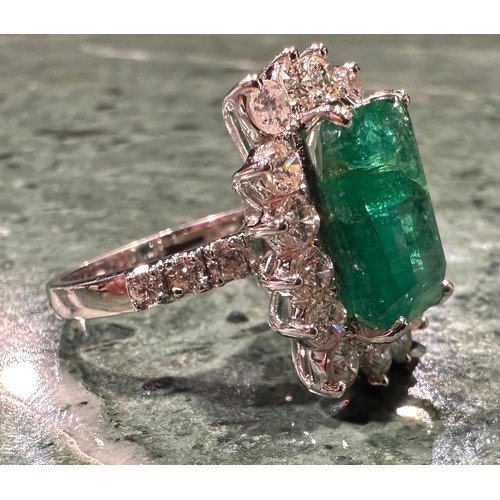 869 - A certified emerald and diamond cluster ring, central Zambian elongated octagonal step cut emerald, ... 