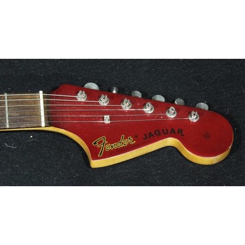 2557 - A Fender Jaguar electric guitar, made in Japan, serial number E555096, finished in deep red, 102cm l... 