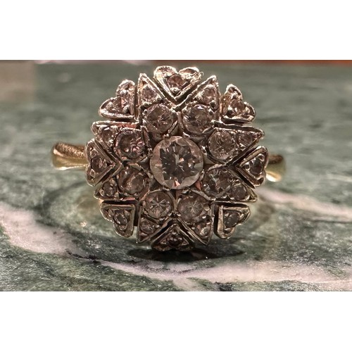 875 - A diamond cluster ring, eight point star and heart crest set with twenty five round old brilliant cu... 