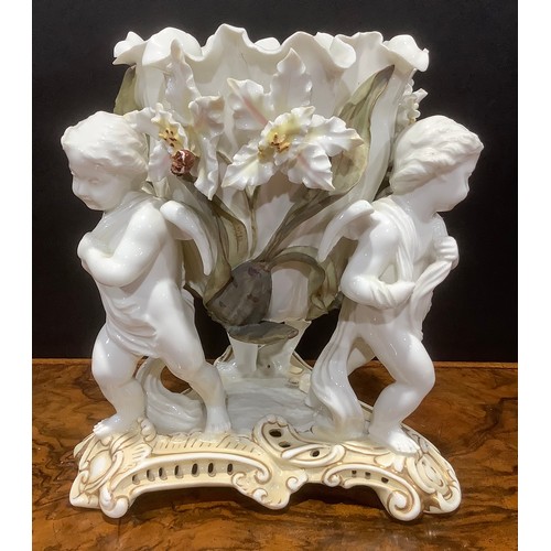 139 - A Moore Brothers figural table centre, in the white, picked out in muted colours, modelled with thre... 