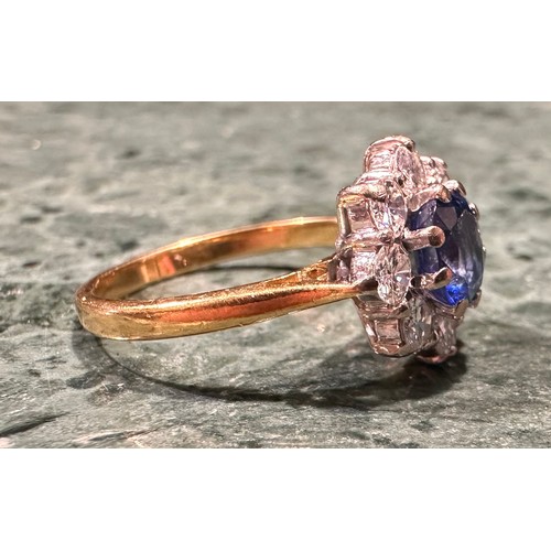 941 - An 18ct gold, sapphire and diamond ring, the central round facet cut stone within eight round brilli... 