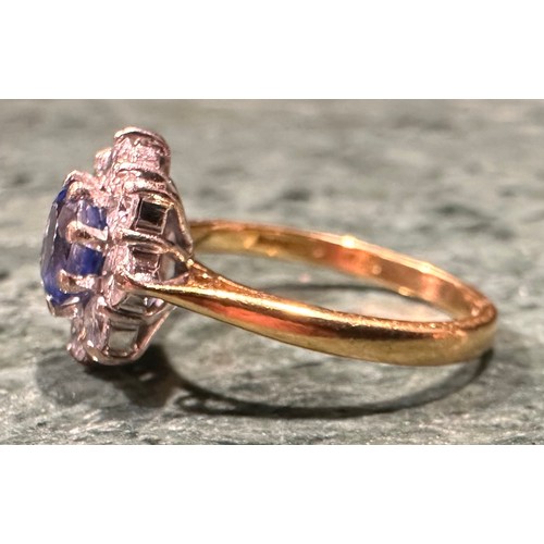 941 - An 18ct gold, sapphire and diamond ring, the central round facet cut stone within eight round brilli... 