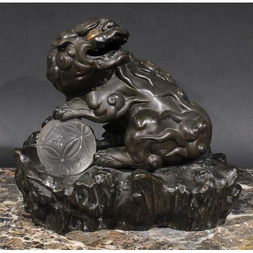 436 - A Chinese brown patinated bronze censer and cover, cast as a temple lion, his paw resting on a glass... 