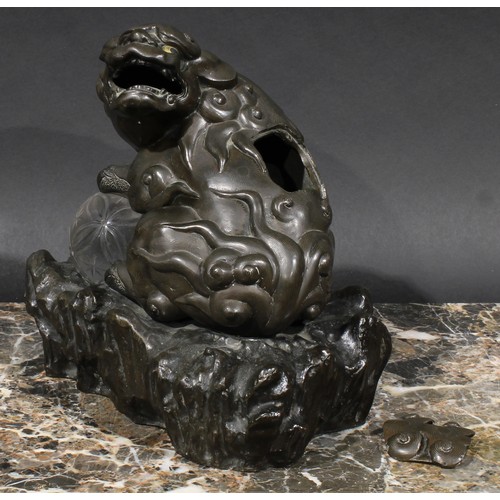 436 - A Chinese brown patinated bronze censer and cover, cast as a temple lion, his paw resting on a glass... 