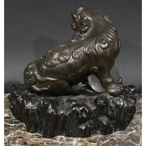 436 - A Chinese brown patinated bronze censer and cover, cast as a temple lion, his paw resting on a glass... 