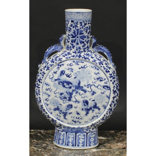 430 - A pair of Chinese moon flasks, painted in tones of underglaze blue with temple lions, on a ground of... 