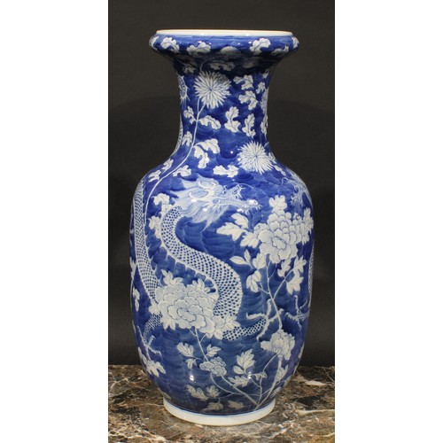 413 - A Chinese ovoid vase, painted in tones of underglaze blue with dragons amogst peonies and foliage, o... 