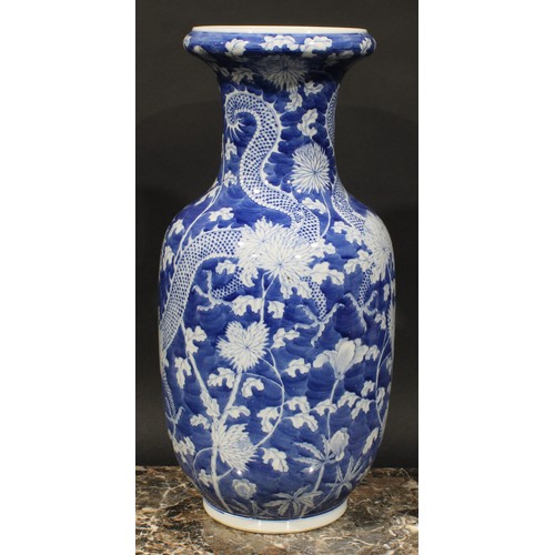 413 - A Chinese ovoid vase, painted in tones of underglaze blue with dragons amogst peonies and foliage, o... 