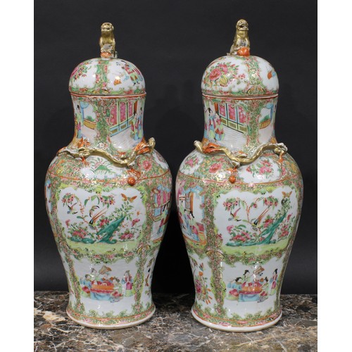 352 - A pair of Cantonese baluster vases and covers, painted in the famille rose palette with figures, bir... 