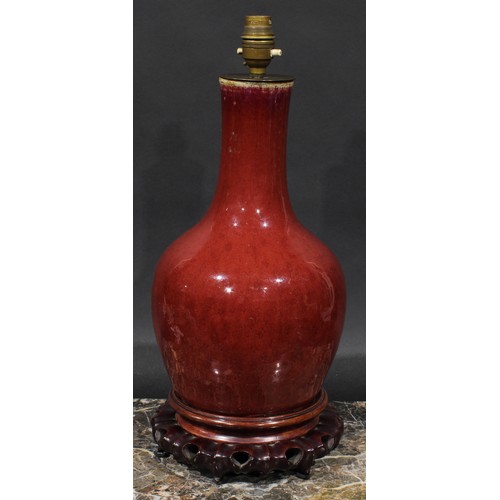 407 - A Chinese monochrome ovoid vase, mounted as a lamp, sang de boeuf glaze, pierced and carved hardwood... 