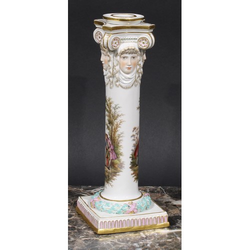 268 - A pair of Meissen columnar candlesticks, each moulded with masks and painted with a courting couple,... 