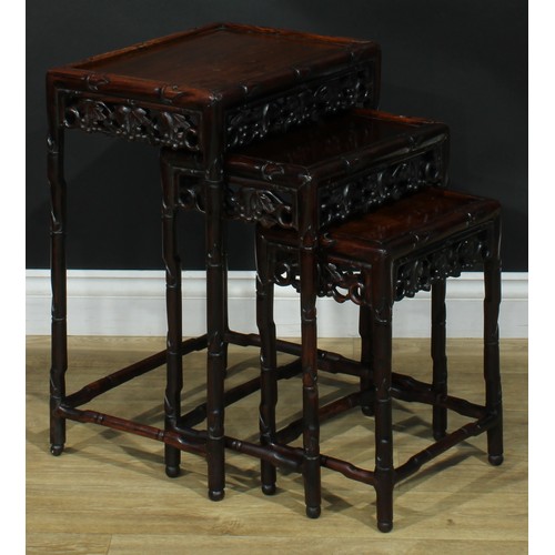 1300 - A Chinese hongmu nest of three occasional tables, each with a rectangular top, the frame carved as l... 