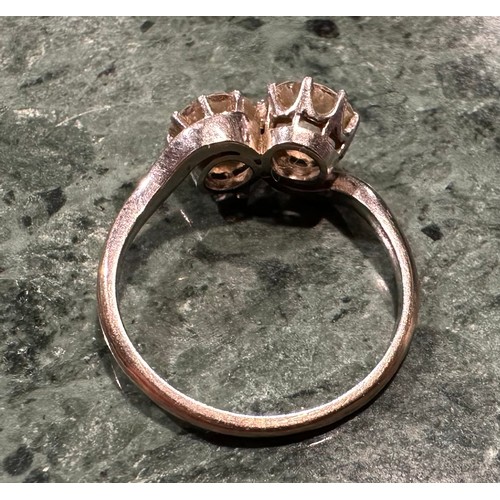 936 - An old brilliant cut diamond twist ring, twisting crest set with two round diamonds each measuring a... 