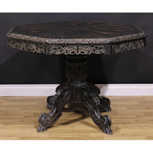 1285 - A 19th century Anglo-Indian ebony centre table, octagonal top with well-figured radiating veneers an... 