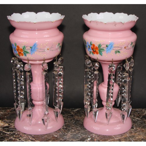 322 - A pair of Victorian pink and white opaque glass table lustres, painted with a band of stylised flowe... 