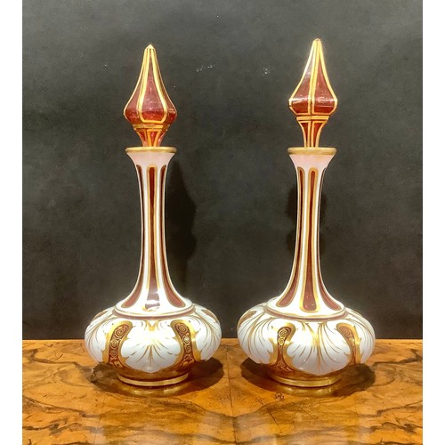 314 - A pair of 19th century Bohemian cased milk and cranberry glass scent bottles, elongated faceted neck... 