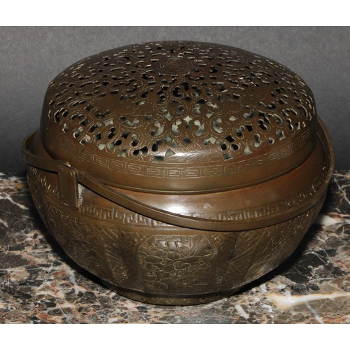 402 - A Chinese brass melon shaped hand warmer or brazier, pierced, chased and engraved, swing handles, 16... 