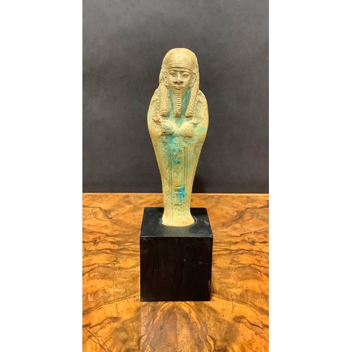 2573 - Antiquities - an Egyptian shabti, traces of turquoise glaze, 15cm high, collector's display plinth