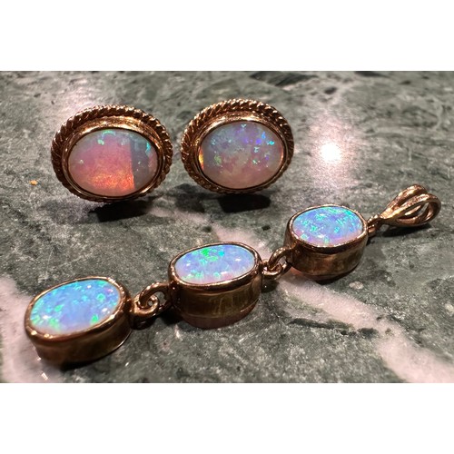 938 - An opal pendant and earring suite, articulated oval three stone linear pendant, with strong blue gre... 