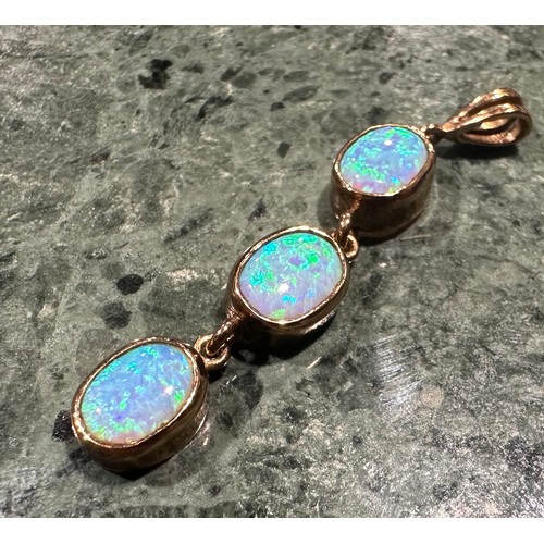 938 - An opal pendant and earring suite, articulated oval three stone linear pendant, with strong blue gre... 