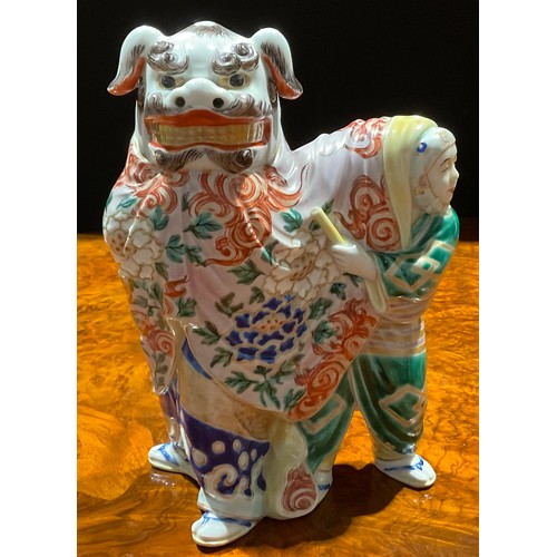 464 - A Japanese porcelain figure, as a pair of dancers in Chinese temple lion costume, the rear dancer pe... 