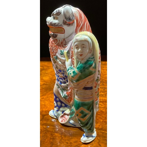 464 - A Japanese porcelain figure, as a pair of dancers in Chinese temple lion costume, the rear dancer pe... 