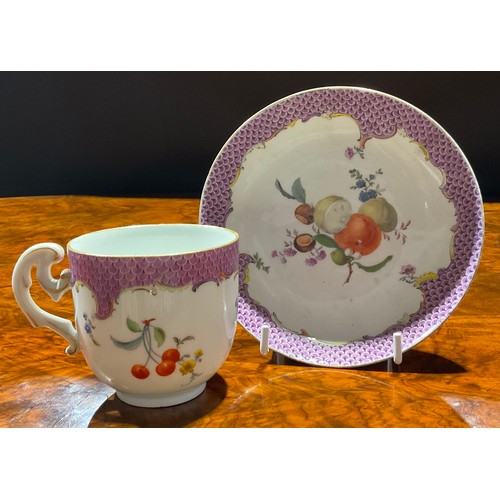 259 - A Meissen coffee cup and saucer, painted with ripening fruit and nuts, under a puce scale border, gi... 