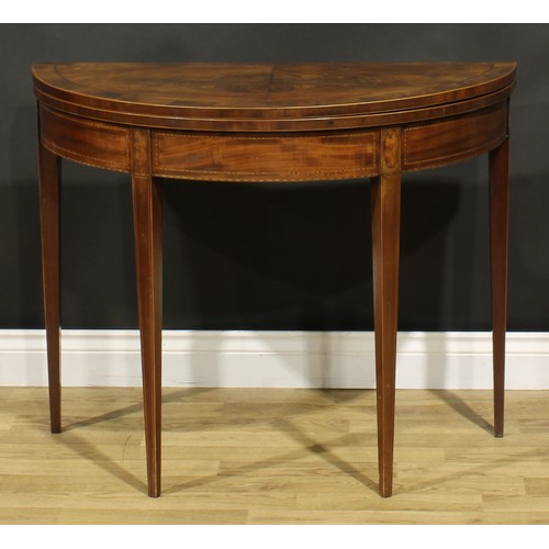 1307 - A George III mahogany demilune card table, hinged top enclosing a baize lined playing surface, taper... 