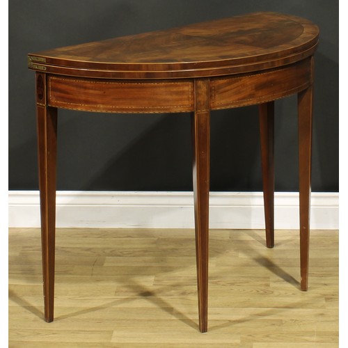 1307 - A George III mahogany demilune card table, hinged top enclosing a baize lined playing surface, taper... 