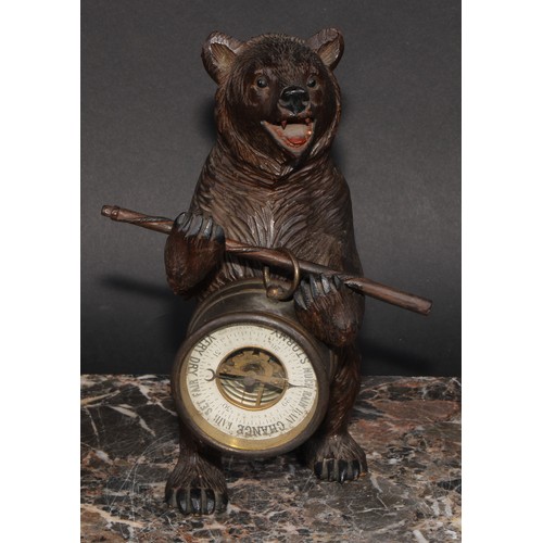 2211 - An early 20th century Black Forest carving, of a bear, holding an aneroid barometer, 21cm high