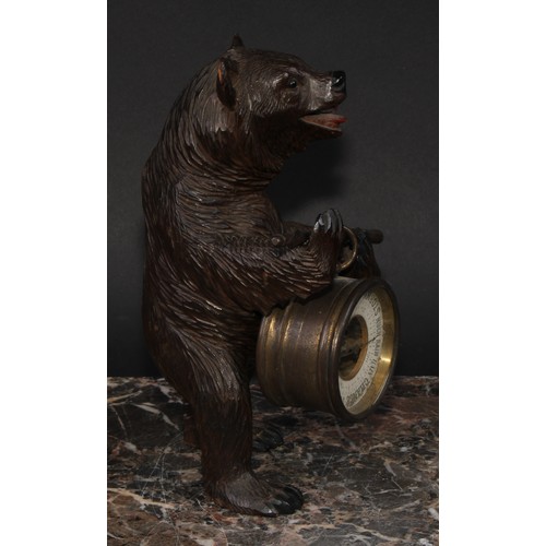 2211 - An early 20th century Black Forest carving, of a bear, holding an aneroid barometer, 21cm high