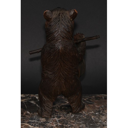 2211 - An early 20th century Black Forest carving, of a bear, holding an aneroid barometer, 21cm high