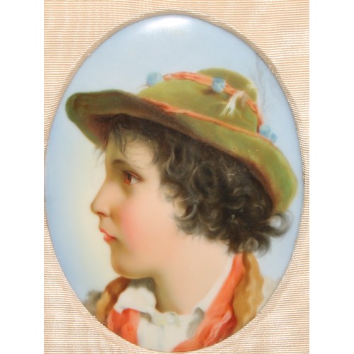 253 - A 19th century German porcelain oval plaque, probably Berlin, portrait of a young boy wearing a hat,... 