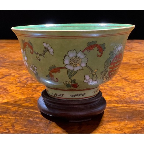 390 - A Chinese circular bowl, decorated in polychrome enamels with flowers and symbol on an apple green g... 