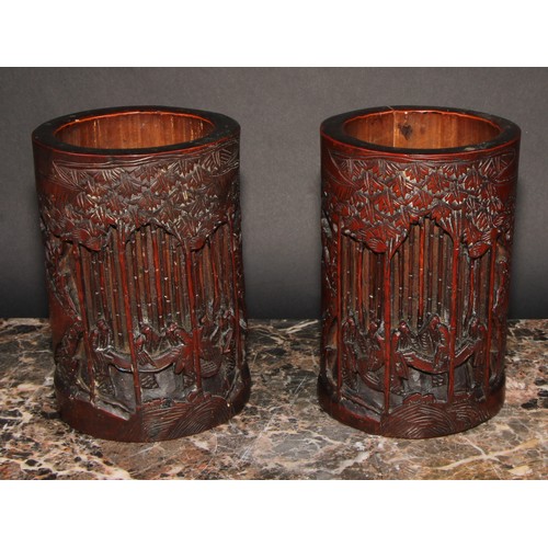 372 - A pair of Chinese bamboo bitong brush pots, carved with figures amongst trees, 18.5cm high, early 20... 