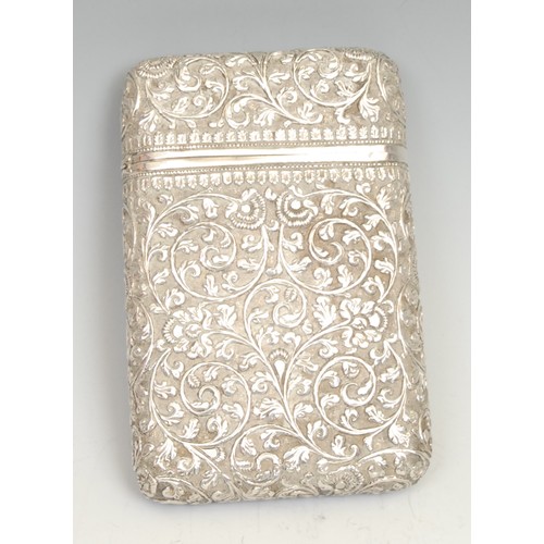 535 - A 19th century Indian silver rounded rectangular cigar case, profusely chased with scrolling lotus a... 