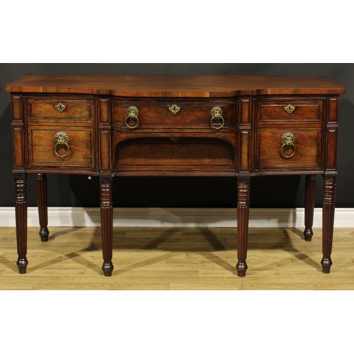 2202 - An unusual Regency mahogany sideboard or serving table, slightly oversailing top above a central fri... 