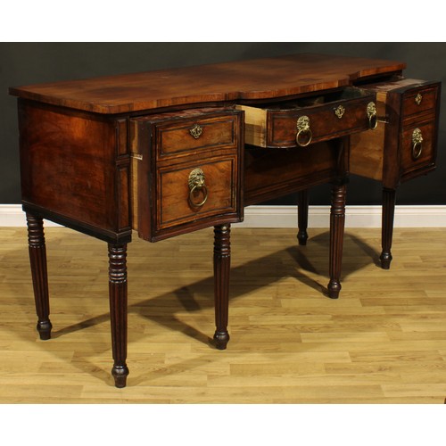 2202 - An unusual Regency mahogany sideboard or serving table, slightly oversailing top above a central fri... 