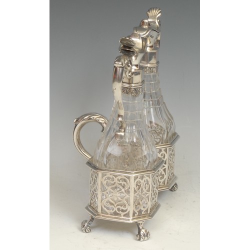 769 - An early Victorian silver oil and vinegar cruet stand, facetted bottles, the canted frame with scrol... 