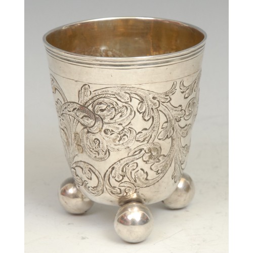 741 - An 18th century Russian silver beaker, chased with scrolling foliage, ball feet, gilt interior, 8.5c... 