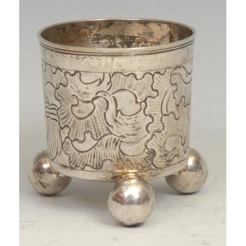 740 - An 18th century Russian silver beaker, chased with flowering scrolls, ball feet, gilt interior, 6cm ... 