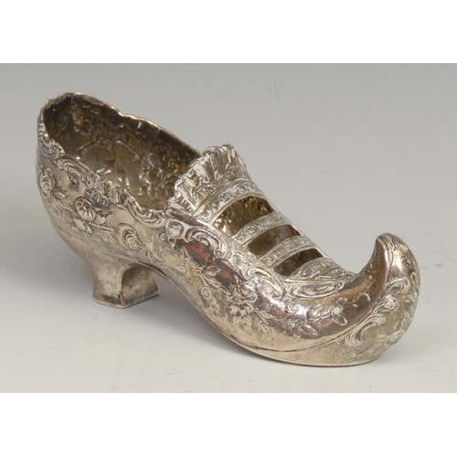 758 - An early 20th century Continental silver novelty model, of a shoe, chased with flowers, 11.5cm long,... 