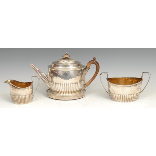 588 - A George III silver four piece half-fluted tea service, comprising teapot, milk jug, sugar basin and... 