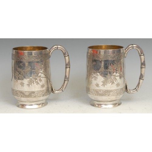 655 - A pair of Chinese silver pint mugs, each engraved with with birds on branches, and insects, within b... 