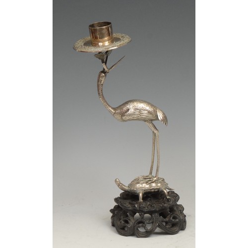 541 - A Chinese silver candlestick, as a crane standing on a turtle, pierced and carved hardwood base, 24.... 