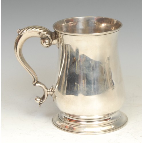 572 - A George II silver bell shaped mug, quite plain, acanthus capped double-scroll handle, skirted base,... 