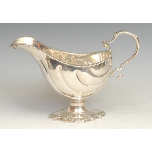 764 - An early George III Rococo silver pedestal sauce boat, gadrooned borders, acanthus capped double-scr... 