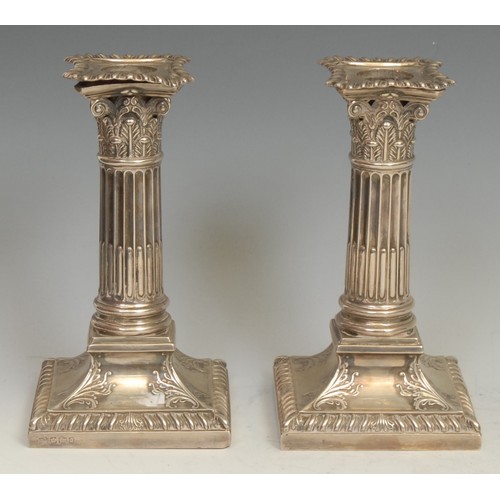 678 - A pair of Victorian silver stop-fluted Corinthian column candlesticks, spreading square bases, gadro... 